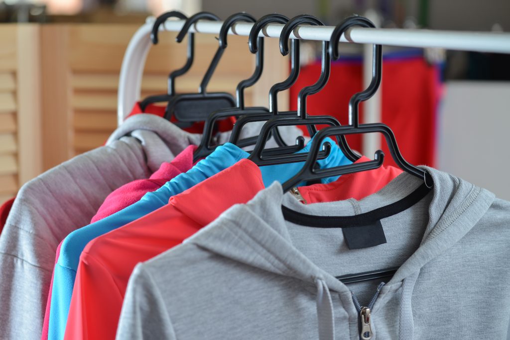 colorful sport shirts and jackets hanging on clothes rack at a fashion store